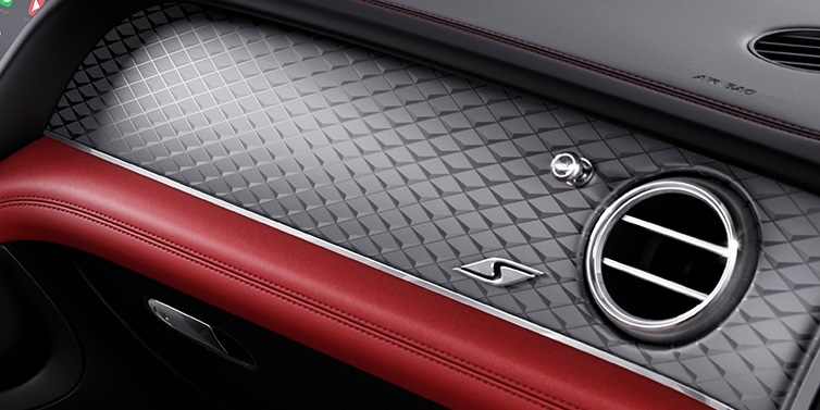 Bentley Al Khobar Bentley Bentayga S SUV front interior dash with Dark Tint Diamond Brushed Aluminium veneer and S badge surrounded by Hotspur red and Beluga black hide
