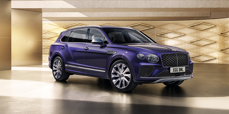 Bentley Al Khobar Bentley Bentayga Extended Wheelbase Mulliner SUV front three quarter in Tanzanite Purple paint with a gold patterned background