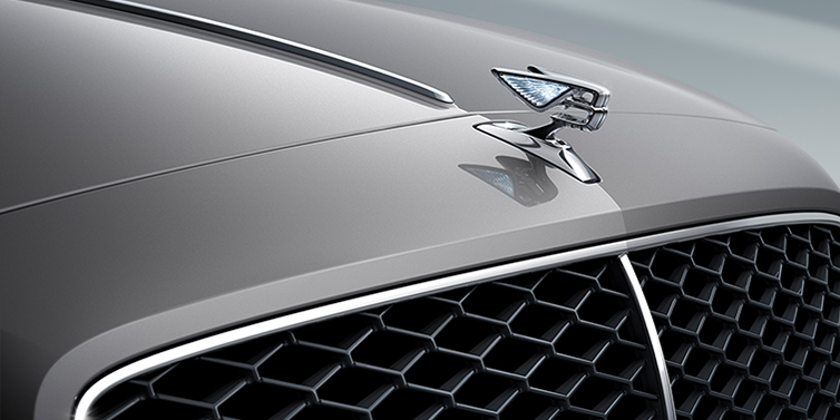 Bentley Al Khobar New Bentley Flying Spur sedan bonnet detail in Silverlake paint with Illuminated Flying B bonnet badge and matrix grille with chrome surround