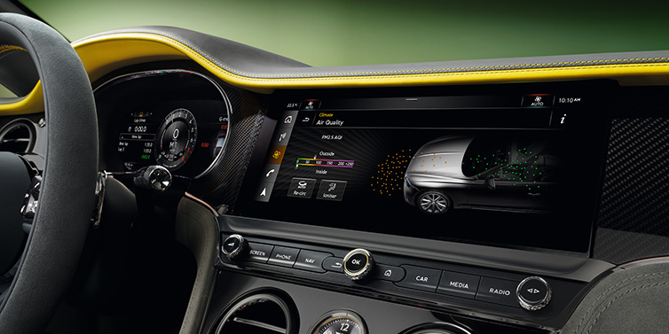 Bentley Al Khobar Bentley Continental GTC Speed convertible front interior centre console with MMI screen showing Air Quality visualisation surrounded by Cyber Yellow by Mulliner and Gravity Grey hides and high gloss carbon fibre veneer