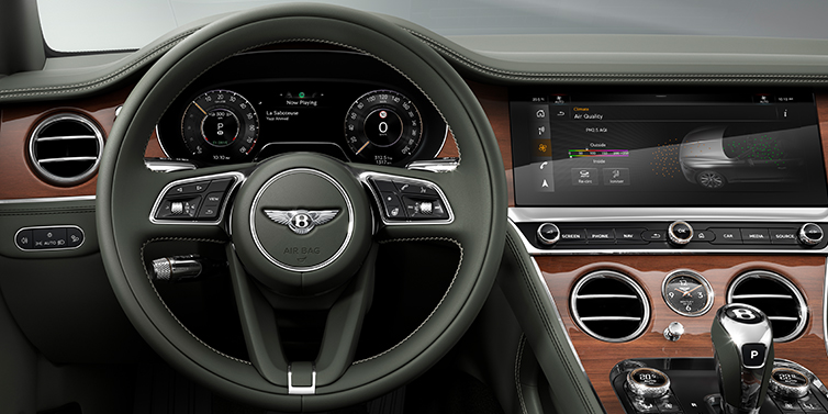 Bentley Al Khobar New Bentley Continental GT coupe steering wheel and front cabin view in Cumbrian Green hide and Crown Cut walnut veneer