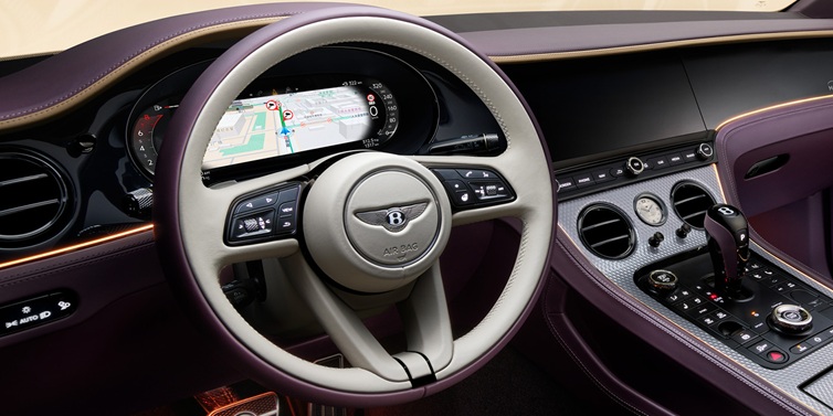 Bentley Al Khobar Bentley Continental GT Mulliner coupe front interior showing steering wheel and drivers screens surrounded by Linen and Damson hides and Grand Black veneer